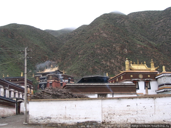 Крыши и стены монастыря удивительно гармонируют с горами вокруг Провинция Ганьсу, Китай