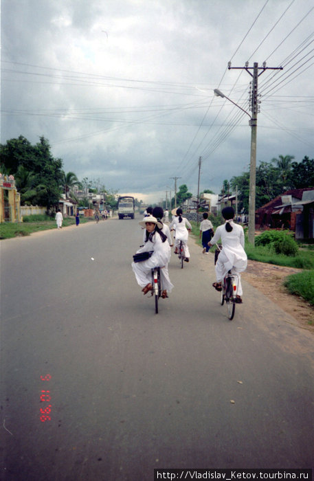 Девушки на велосипедах. Удивительно, но такие белые одежды они носят ежедневно. Камбоджа