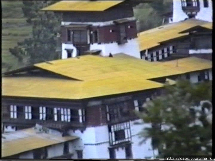Монах сидит на крыше Тонгса, Бутан
