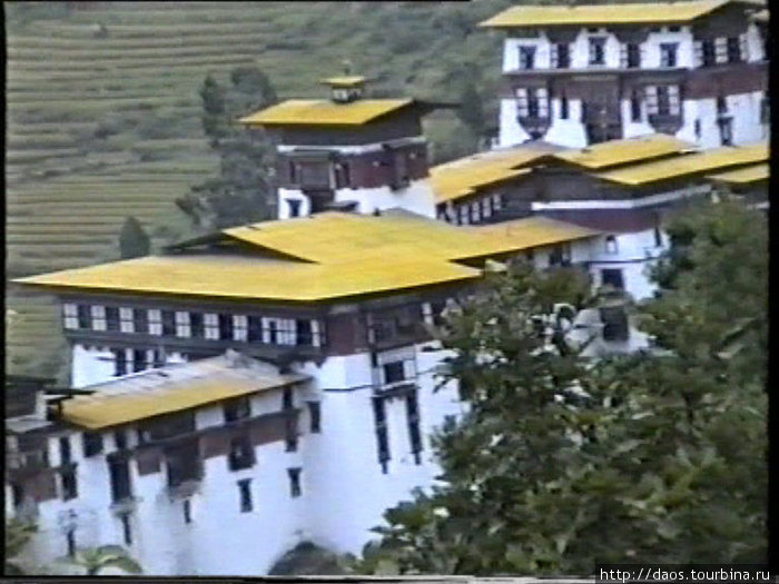 А на крыше в медитации сидит монах — маленькая точка под башней Тонгса, Бутан