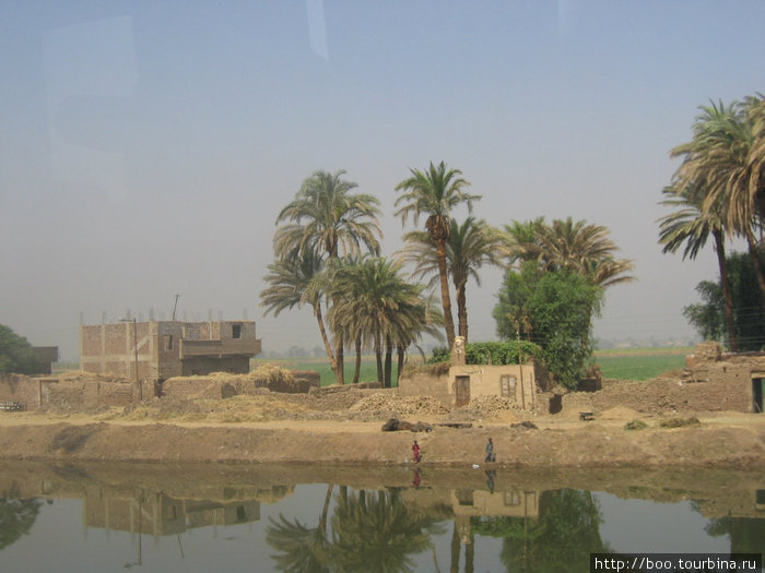 пригородные дома с вечными придорожными канавами Луксор, Египет