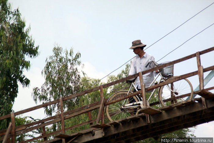 Велосипедист на мосту Дельта реки Меконг, Вьетнам
