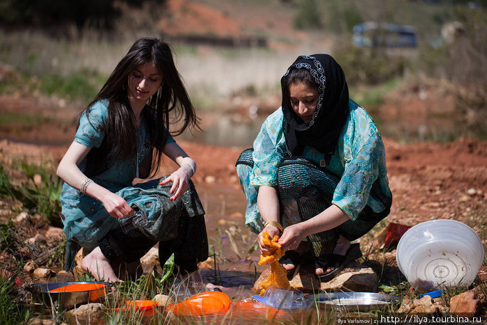 Женщины моют посуду в ручье. Ирак