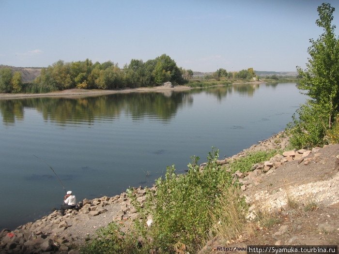 Рыбаки ловят рыбу, сидя на берегу на камнях, или на лодках выходят в залив. Калач-на-Дону, Россия