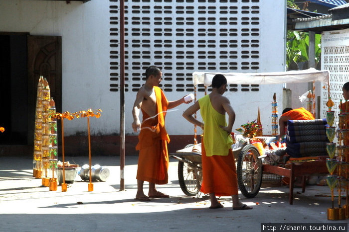 Монахи разбираются с украшениями к празднику Вьентьян, Лаос