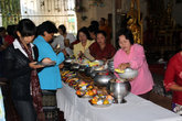 Женщины жертвуют монахам пищу собственного приготовления и магазинную