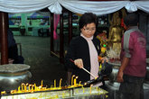 Паломники зажигают свечи перед входом в монастырь Ват Яй