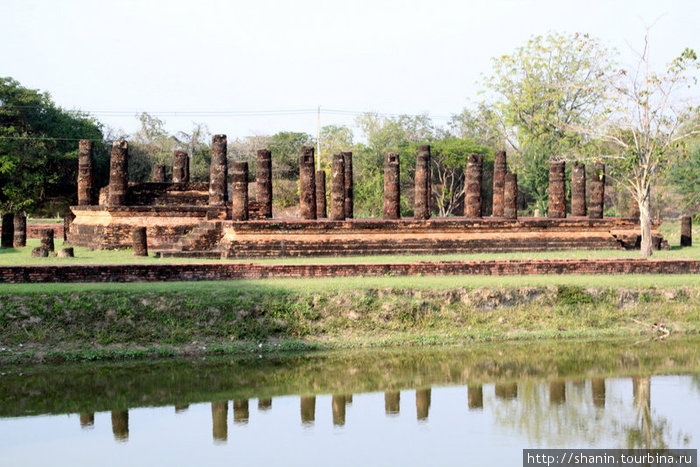 Руины храма и их отражение в заполненном водой крепостном рву Сукхотай, Таиланд
