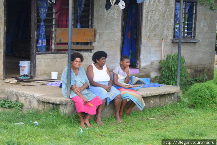 А женщины с детьми сидят у своих домов и общаются о жизни Остров Вити-Леву, Фиджи