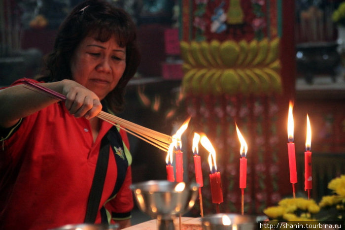 Китаянка зажигает ароматные палочки Куала-Лумпур, Малайзия