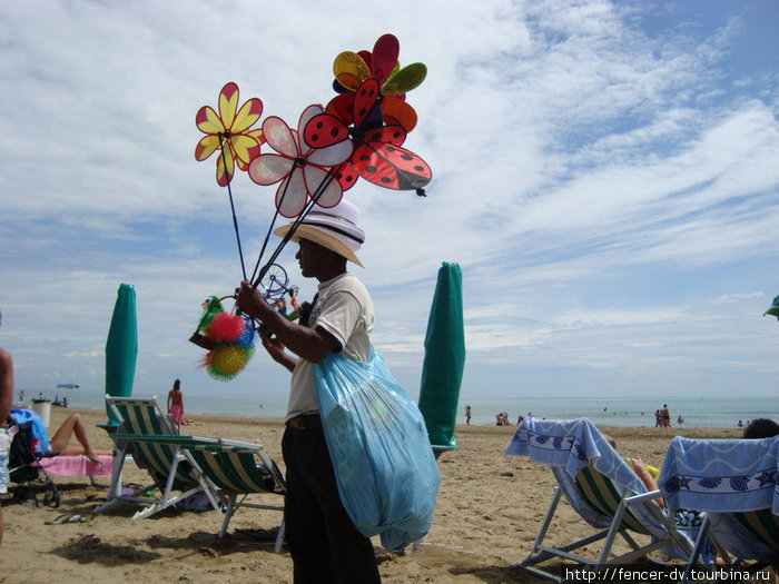 На пляжах постоянно продают какую-нибудь ерунду от ремней до воздушных змеев. Езоло, Италия