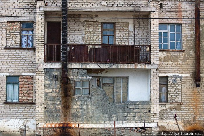 Так как печкой дырявую квартиру особо не натопишь, люди закладывают лишние окна кирпичом. Аральск, Казахстан