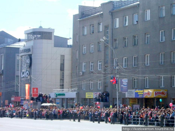 Многочисленные зрители расположились не только на тротуаре, но и на крышах торговых павильонов. Новосибирск, Россия