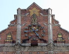 На короне фасада здания — пятиконечная стилизованная кирпичная звезда с часами на Спасской башне, по бокам – силуэты кремлевских башен.