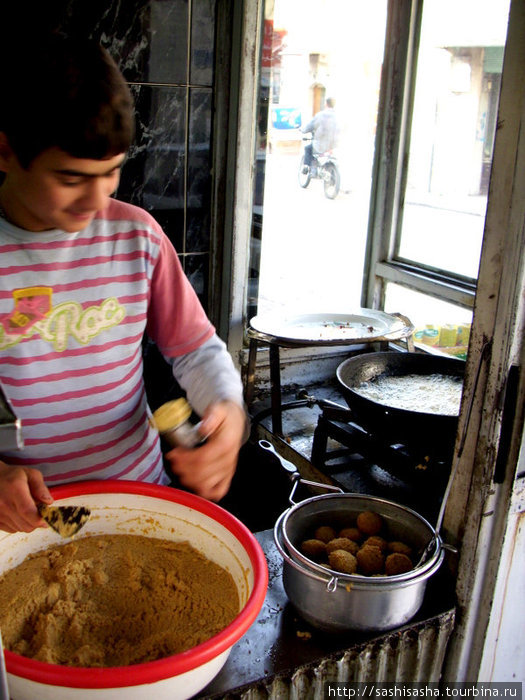 Вот так молодой мальчишка, сын хозяина кафе, лихо стряпает фалафель. Сирия
