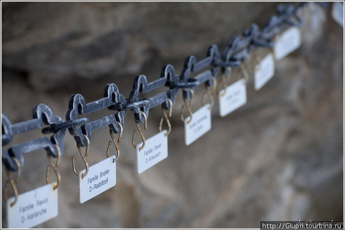 Вокруг скалы натянута цепь с фамилиями семей, живущих в городке под этой горой. Ленгенфельд, Австрия