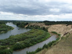 Панорама реки Медведицы вниз по течению с островом и лесными массивами за рекой.