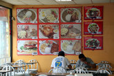 Меню нет. Фото блюд с ценами вывешаны прямо на стене.