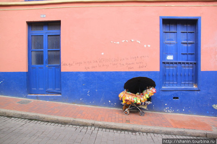 Тележка с товаром у стены дома Богота, Колумбия