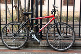 Велосипед у ограды пристегнут, чтобы не украли