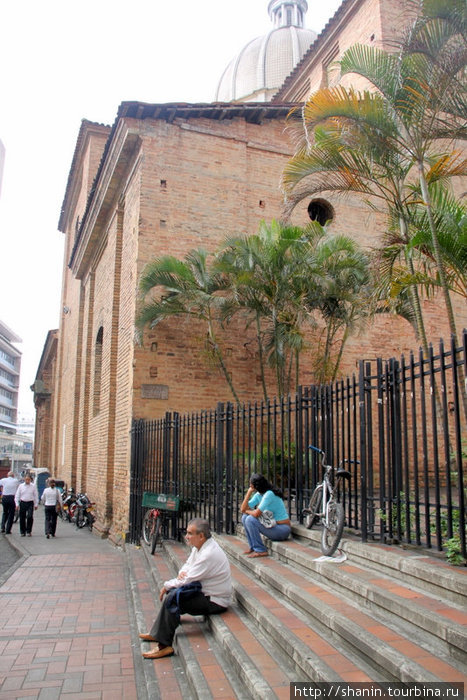 Перед закрытой решеткой у бокового входа в церковь Кали, Колумбия