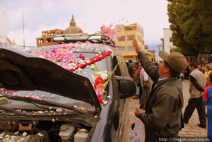 После молитвы священник осыпает машину лепестками цветов