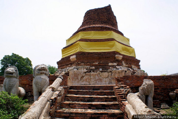 Празднично украшенная полуразрушенная кирпичная ступа в монастыре Ват Туммикарат Аюттхая, Таиланд