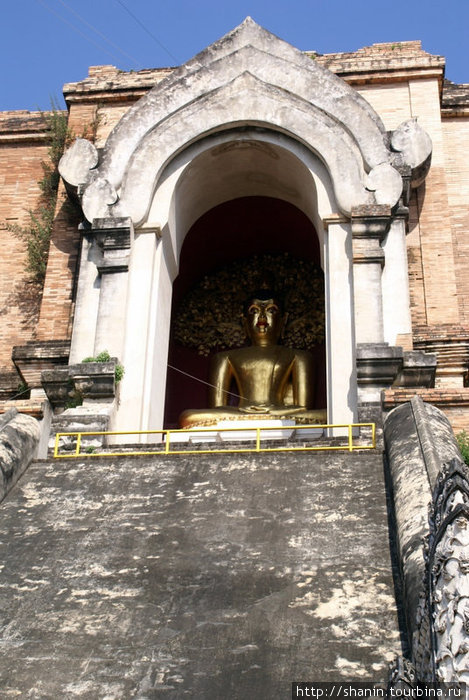 Золотой Будда в нише на вершине ступы в Вате Чеди-Луанг