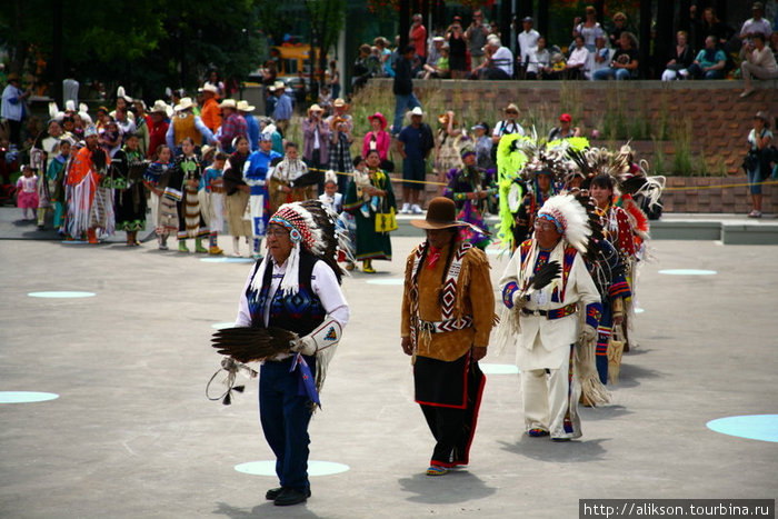 Пешие индейцы вышли пританцовывая, возглавляемые пожилым индейцем в джинсах. Банфф, Канада
