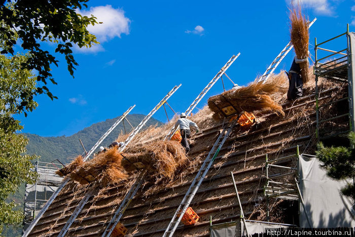 Перекрывают крышу одного из домов в музее Огимати, Япония