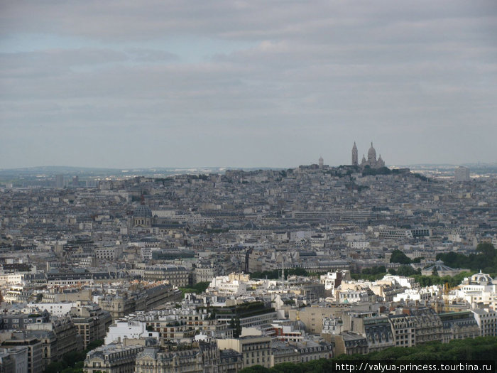 Вид на город с Эйфелевой башни. Вдали виднеется церковь Сакре-Кёр, находящаяся на холме Монмартр Париж, Франция