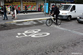 В некоторых местах, где велодорожки нет, есть большой велосипед, нарисованный на проезжей части — это значит, что велики могут здесь ездить и останавливаться перед автомобилями.