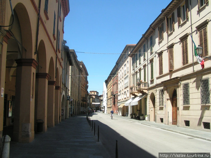 Справа дома, слева магазины Реджо-Эмилья, Италия