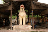 Белый лев у деревянного храма
