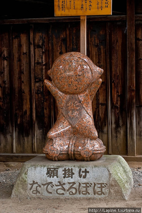 Каменный сарубобо у входа в храм Такаяма, Япония