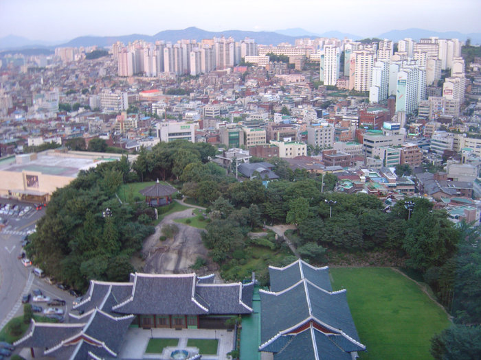 Еще один вид, зеленое внизу  с национальными крышами в зеленой зоне — это все территория отеля. Сеул, Республика Корея