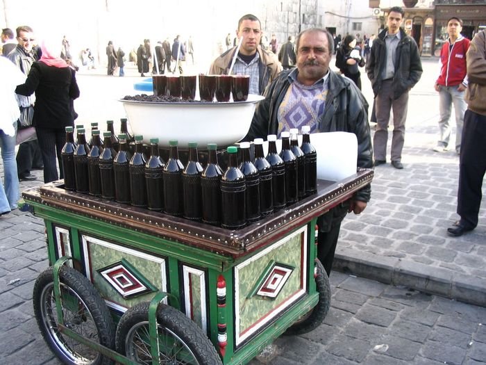 В Дамаске я опробовала еще одну местную достопримечательность — компот из шелковицы! За бутылками лежит полено льда. Торговец стругает его рубанком в стакан и заливает шелковичным соком. Ничего так получается, освежает! :-))) Сирия