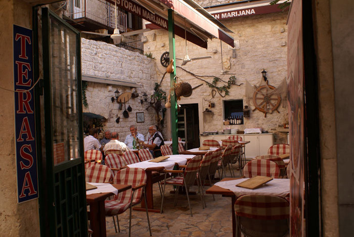 Ресторан во внутреннем дворике под открытым небом Трогир, Хорватия
